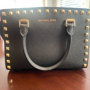 Michael Kors black handbag with gold studs. Includes a crossbody strap.